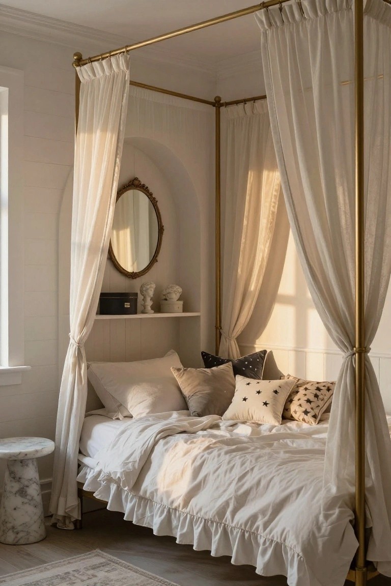 A bedroom corner with a gold four-poster bed draped in white sheer curtains, white bedding with patterned pillows, an arched wall niche containing a gold-framed mirror and white busts on a shelf, a marble side table, and neutral walls and flooring.